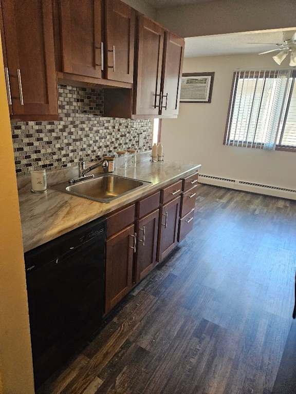 A kitchen with wooden cabinets and a black dishwasher.
