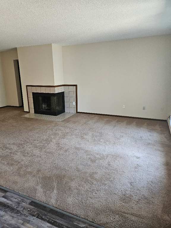A living room with a fireplace and carpeted floor.