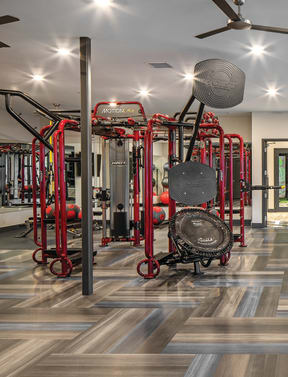 a gym with cardio equipment and chairs on a tiled floor