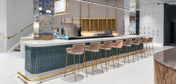 a view of the bar and seating area of a restaurant with green tile and gold bar st