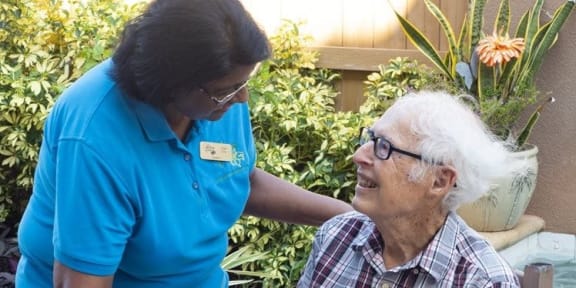 caregiver talking to a resident at Savannah Grand of Sarasota, Sarasota, FL