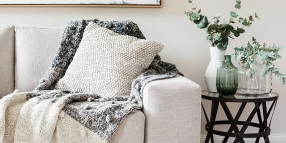 a couch with a blanket and pillows on it