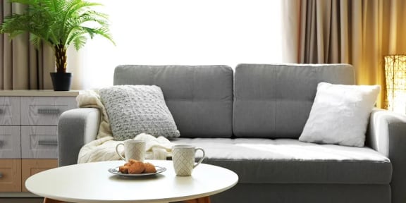 a living room with a gray couch and a white coffee table