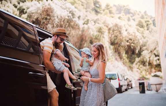 A family of three is getting out of a car.