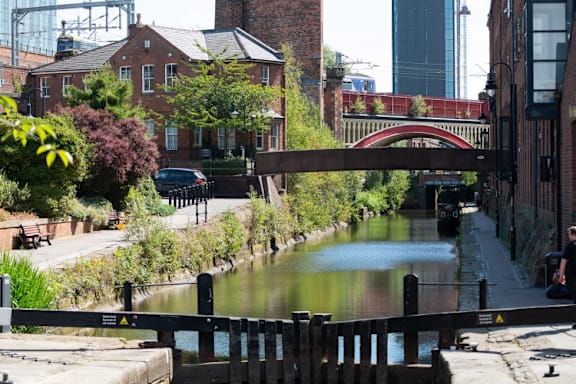 a canal in a city with a bridge over it at The Trilogy Apartments, Manchester, M15 4RU