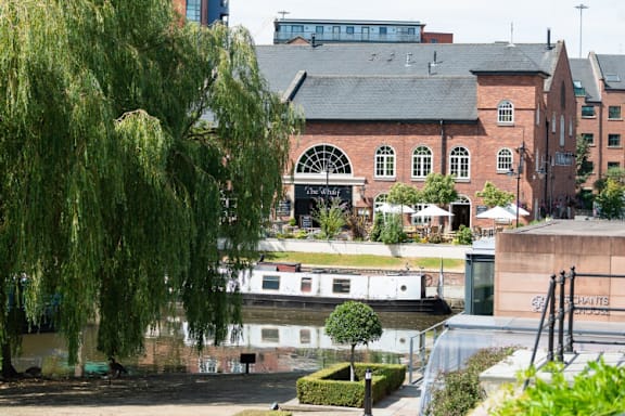 An historic building near the water at The Trilogy Apartments, Manchester, M15 4RU