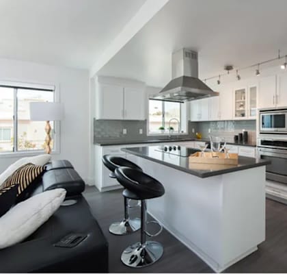 A modern kitchen with a black bench and a wooden island.