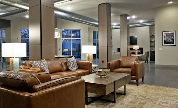 A brown leather couch with a coffee table in front of it.