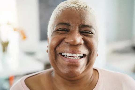 A person with short hair is smiling.