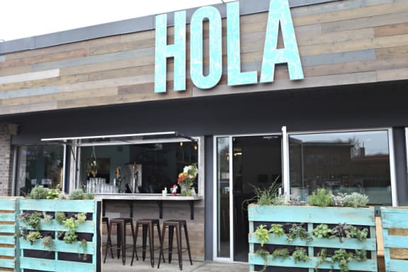 a restaurant with a bar and a hola sign