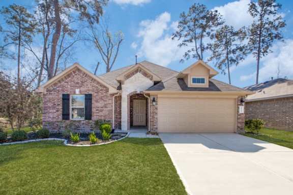 A house with a brown brick exterior and a white garage door.