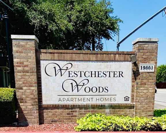 a sign apartment homes in front of a brick wall
