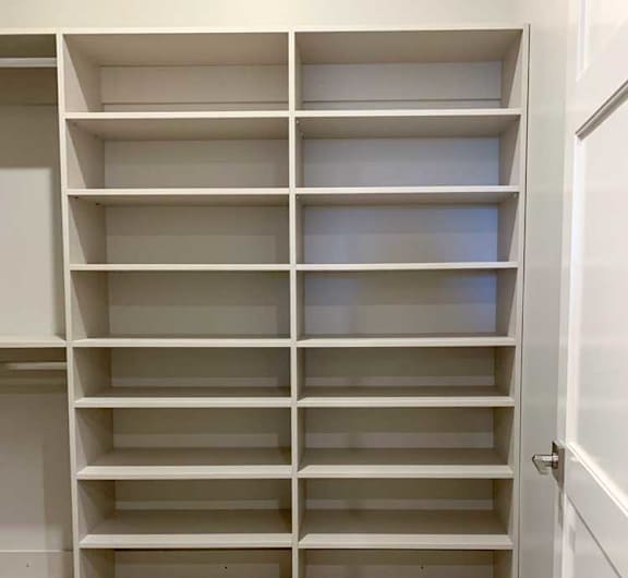 built-in shelves with several levels in a spacious walk-in closet