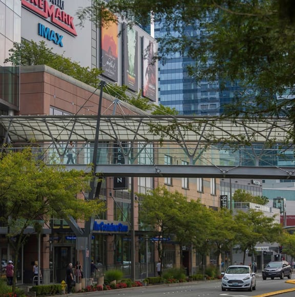 a city street with cars and people and buildings in the background
