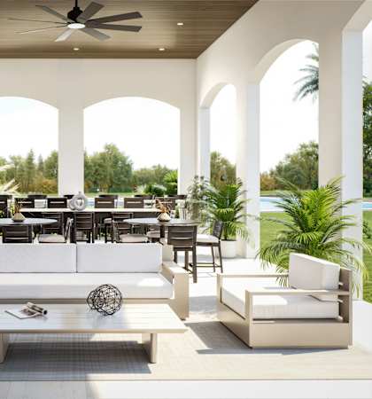 A modern outdoor living space with white furniture and a ceiling fan at Stillwater Lakes Apartments, Florida