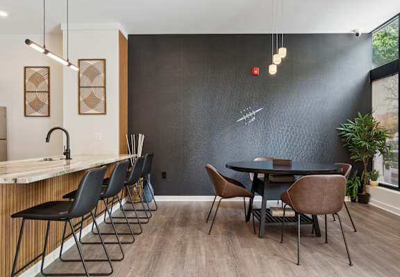 A modern dining room with a black table and chairs.