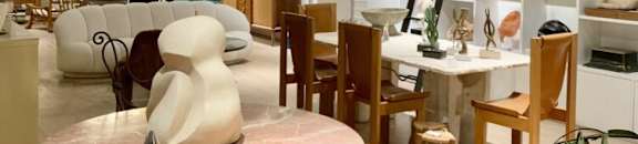 A round table with a green base and a pink marble top is in the center of the room.