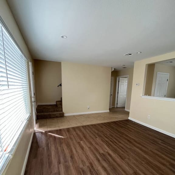 a living room with a wooden floor and a large window