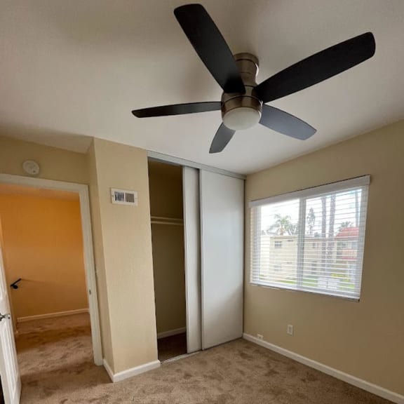a room with a ceiling fan and a window