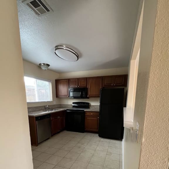 a kitchen with a black refrigerator freezer and a black stove top oven