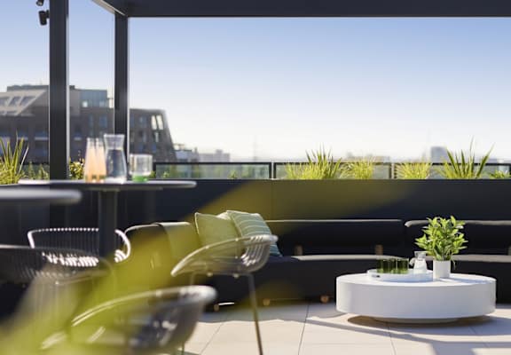 a seating area with tables and chairs on a balcony