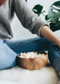 Woman Sitting Down with Bowl of Popcorn