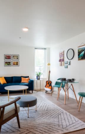 a living room with a blue couch and a table and chairs