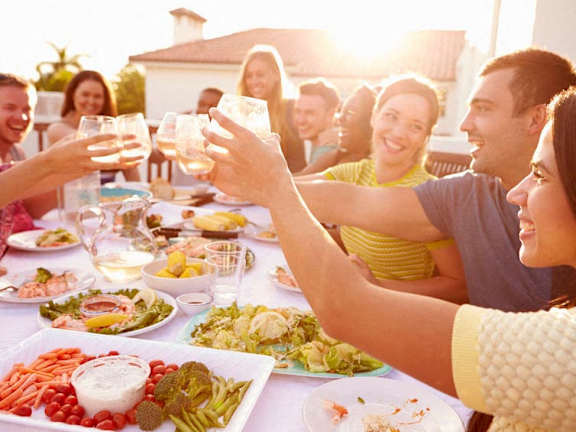 a group of people sitting around a table drinking wine