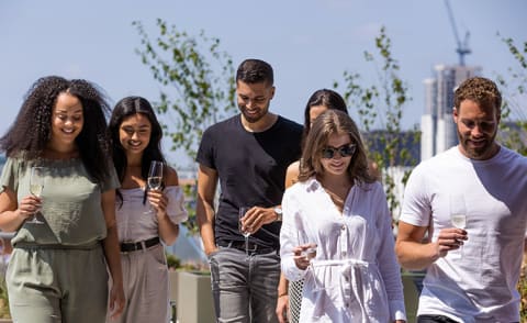 a group of people posing for a picture and drinking wine