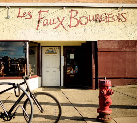 a red fire hydrant in front of a store with a bike