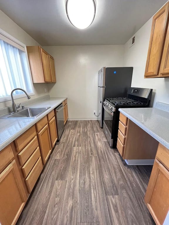 a kitchen with wooden floors and a stove and refrigerator