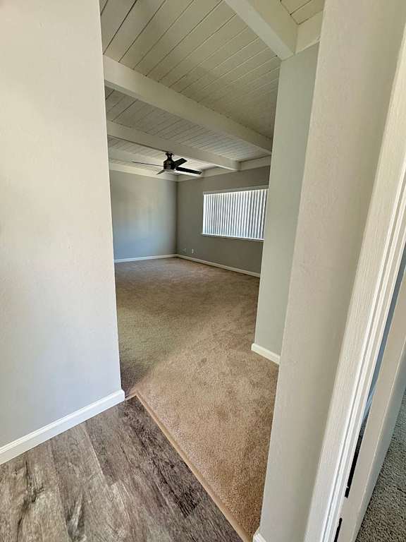 A room with a ceiling fan and a window with blinds.