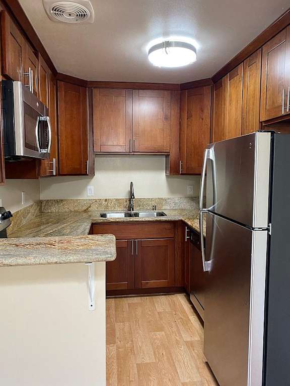 a kitchen with wooden cabinets and a stainless steel refrigerator