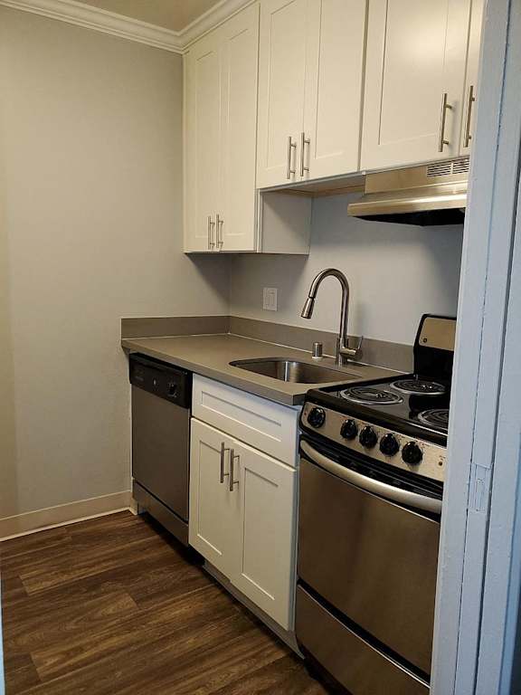 A kitchen with white cabinets and stainless steel appliances.