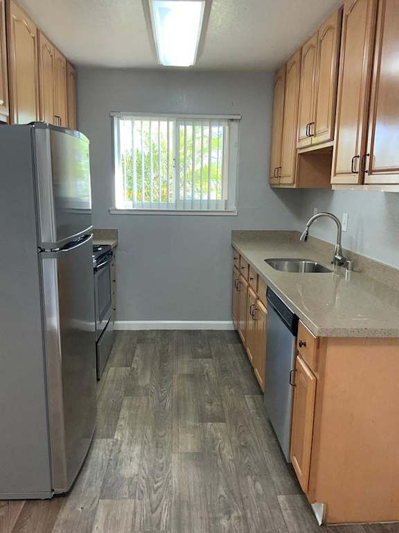 A kitchen with wooden cabinets and a stainless steel refrigerator.
