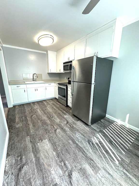 A kitchen with a black refrigerator and white cabinets.