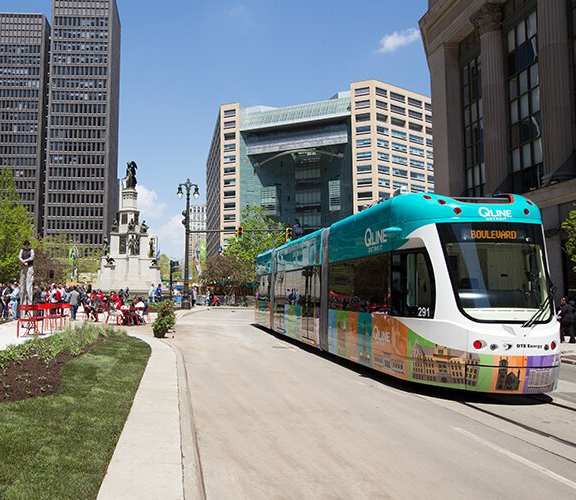 A street with a bus and people sitting at tables at 28Grand, Detroit, MI