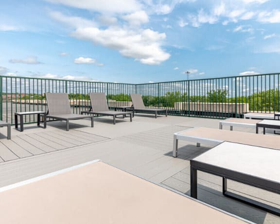 A patio with a table and chairs overlooking a body of water.