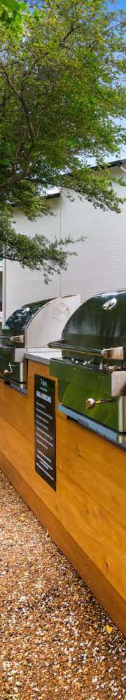 A modern outdoor kitchen area with a grill and seating area.