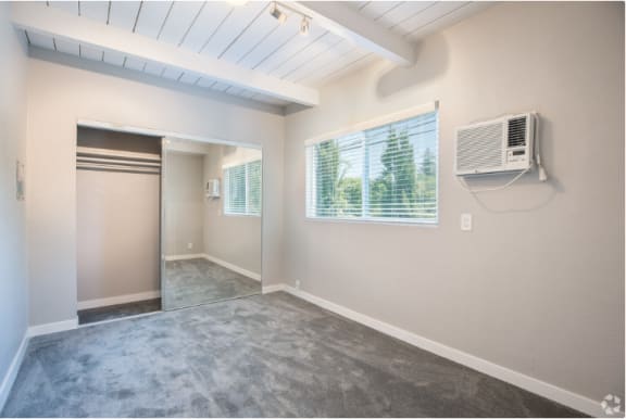 an empty room with an air conditioner on the wall and a door to a