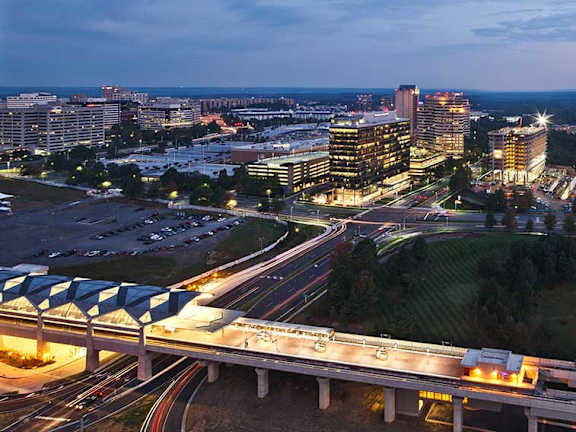 an aerial view of a city at night with highways and buildings