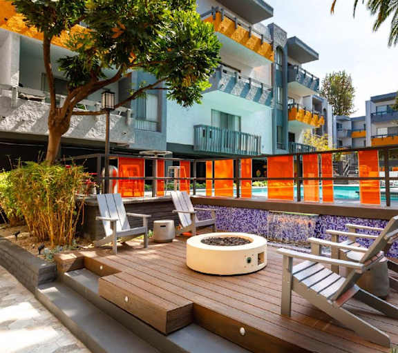A modern outdoor seating area with a hot tub and chairs.