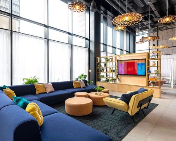 a lobby with blue couches and chairs and a television