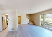 Thumbnail 3 of 22 - A spacious, empty room with a staircase leading to the second floor.