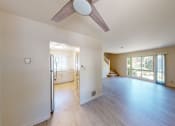 Thumbnail 4 of 22 - A spacious room with a ceiling fan and sliding glass doors.