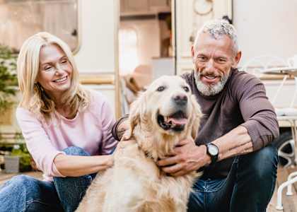 A man and woman sitting outside with a dog.