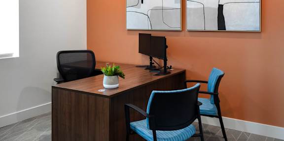 A modern office with a wooden desk and blue chair.