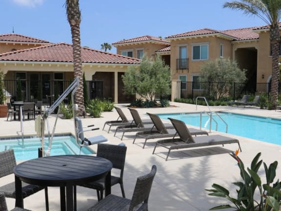 a swimming pool with chairs and tables around it