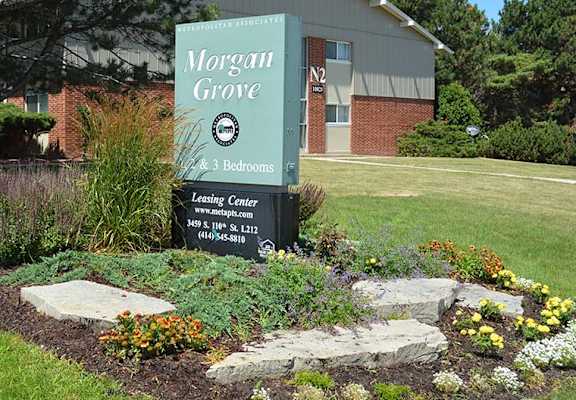 A sign for Morgan Grove Apartments is displayed in front of a building.