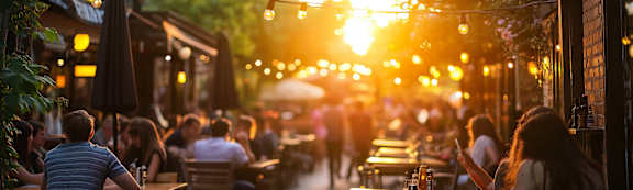 A sunny day at a bustling outdoor restaurant with people dining and enjoying the warm weather.